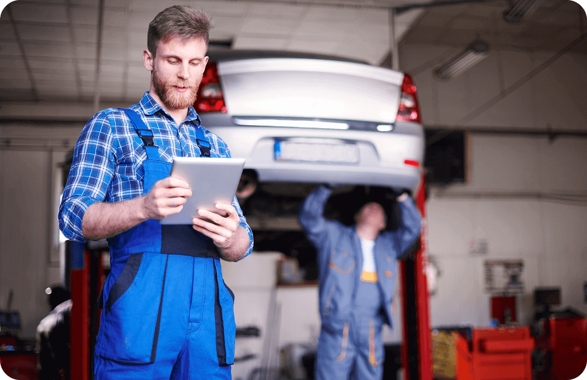 Automotive technician reviewing safety compliance procedures in workshop